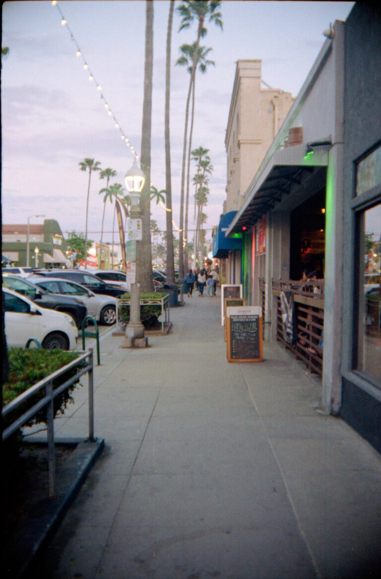 Newport Avenue Ocean Beach San Diego sidewalk at dusk with string lights and palm trees, Yashica Electro 35