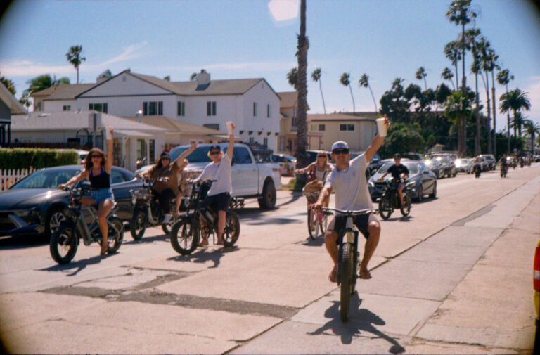 group of cyclists riding down palm lined street in Pacific Beach San Diego, Yashica Electro 35 street photography
