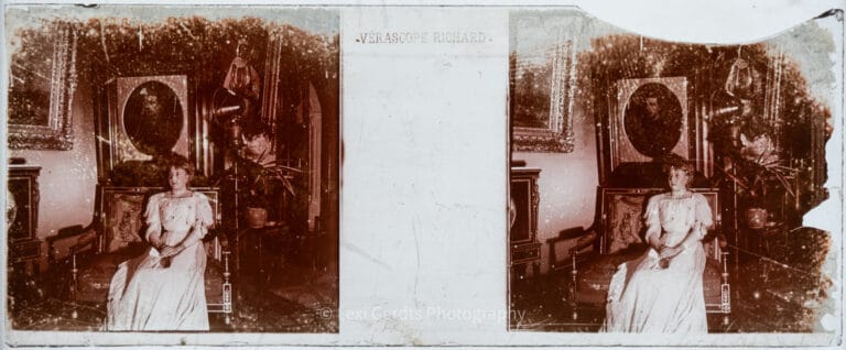 Vérascope Richard 45x107mm stereoscopic glass slide showing a woman in white seated in the Bonaparte portrait gallery at Farnborough Hill, Hampshire, surrounded by gilt-framed paintings, circa 1907–1920. From Empress Eugenie Verascope Richard collection.