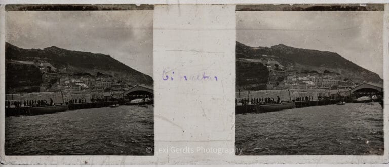 Antique stereoscopic glass slide captioned "Gibraltar" showing the harbour and town with crowds gathered on the mole, the Rock of Gibraltar rising in the background, circa early 1900s. From Empress Eugenie Verascope Richard collection.